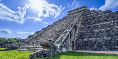 Escalera de piedra con esculturas de serpientes en la piramide de KukulKan en Yucatan , ruinas mayas de Chichen Itza. Hierva verde rodea este espectacular lugar